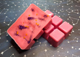 clamshell shaped wax that is colored pink with purple glitter on top
