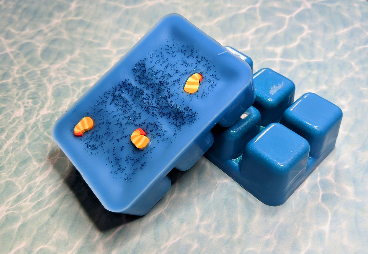 clamshell shaped wax that is colored blue with blue glitter on top
