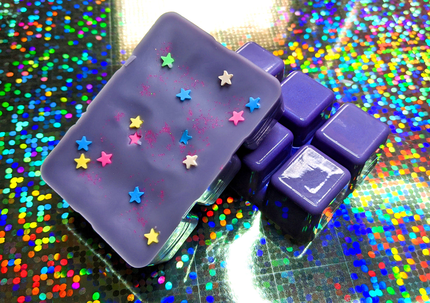 clamshell shaped wax colored lavender with star shaped clay sprinkles on top.