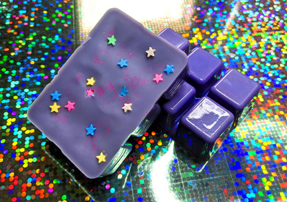 clamshell shaped wax colored lavender with star shaped clay sprinkles on top.