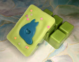 clamshell shaped wax that is colored leaf green with a turquoise totoro shape in the middle, bunny shaped glitter on top.