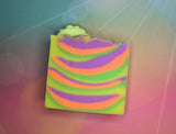 a soap bar that is colored neon yellow, orange, green, and purple with a small taco soap on top.