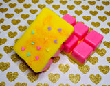 clamshell shaped wax with a neon pink base and yellow on top. Pink glitter and mickey shaped clay sprinkles on top.