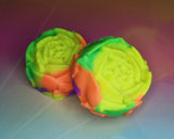 a rose shaped soap bar that is colored neon yellow, orange, green, and purple